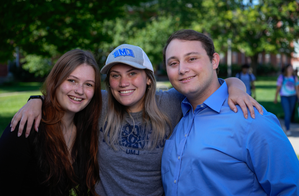 Three students smiling.